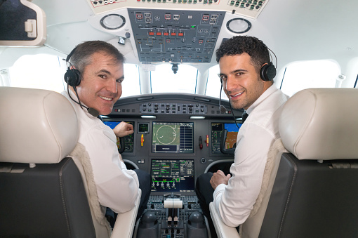 Airplane pilots in the cockpit ready to fly and looking very happy