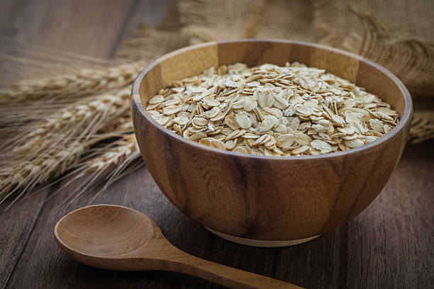 istock Oat flakes in wooden bowl and wheat 513230570