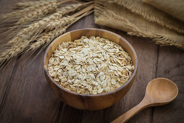 istock Oat flakes in wooden bowl and wheat 513230968