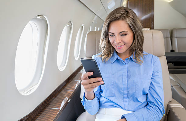 woman traveling by air and texting on the plane - airplane air vehicle business travel passenger imagens e fotografias de stock