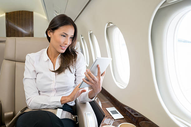 Woman enjoying onboard entertainment in her tablet computer