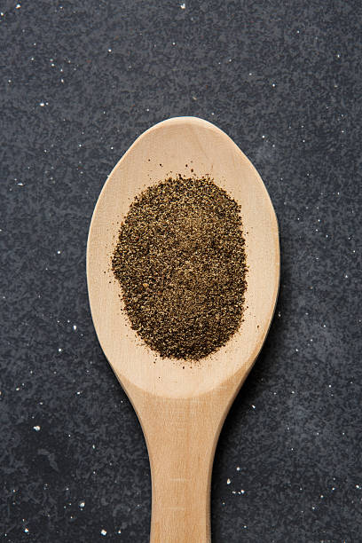 tierra de pimienta negra en una cuchara de madera - spice condiment spoon wooden spoon fotografías e imágenes de stock