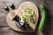 Spiralised courgette beside a spiraliser on heart shaped wooden