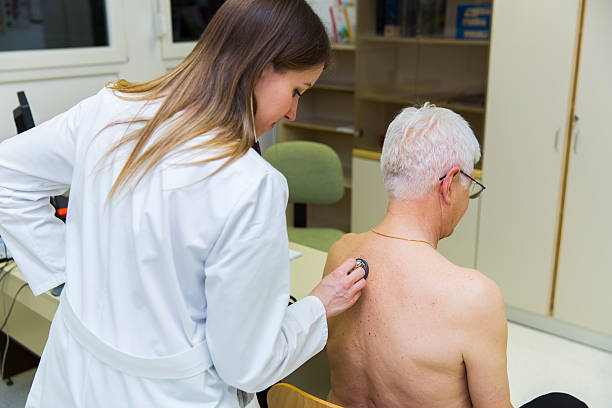 istock Young woman doctor checking patients lungs with stethoscope 513235522