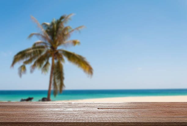 istock Wood table top on blurred blue sea and white sand 513236956