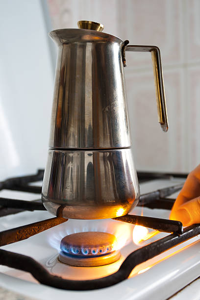 istock hand lighting the gas under the coffeepot 513242902