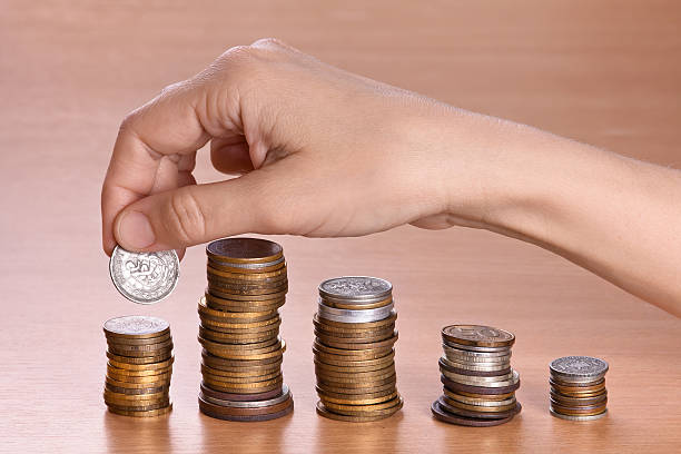 istock hand stacking coins in piles, closeup 513242932