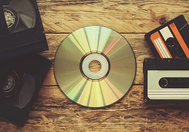 video tapes, audio tapes and compact disc on a wooden table