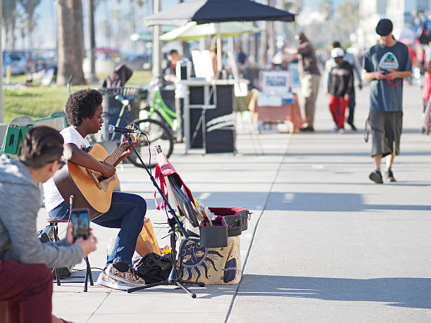 San Francisco, CA, USA August 24 A young man plays the guitar while sitting on the sidewalk in the Haight Ashbury district of San Francisco highlighting the city's homeless issue