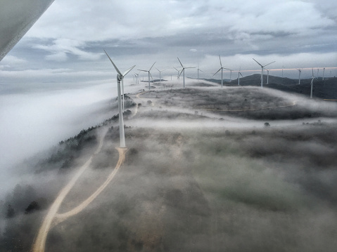 Wind turbines on dense fog. Wind farm in Navarre, Spain. ( Mobilestock )