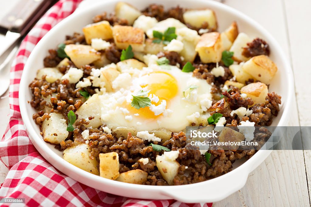 Potato hash with sausage and fried egg Potato hash with sausage and fried egg in a baking dish Breakfast Stock Photo