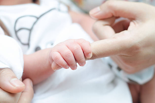 istock Little tiny baby hand holding mother finger 513250703