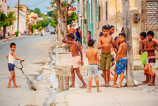 Cienfuegos, Cuba - March 22, 2015: Street with colourful houses in Cienfuegos. Some children are playing in the street. 
