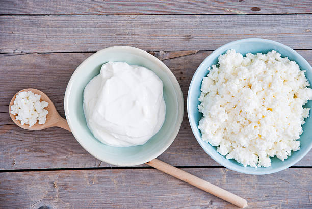 Fresh cottage cheese and Sour cream Organic Farming Cottage cheese and Sour cream in a blue bowl cottage cheese photos stock pictures, royalty-free photos & images