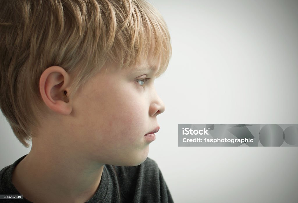 Scared child staring into space portrait of a young worried child Boys Stock Photo