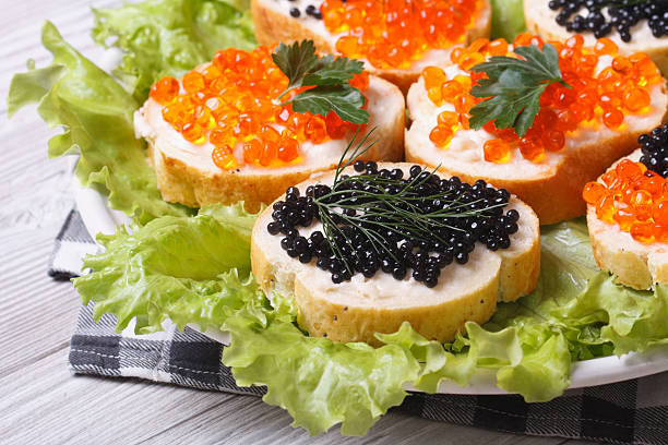 sanduíches com caviar vermelho e preto de peixe - heap caviar animal egg fish roe - fotografias e filmes do acervo