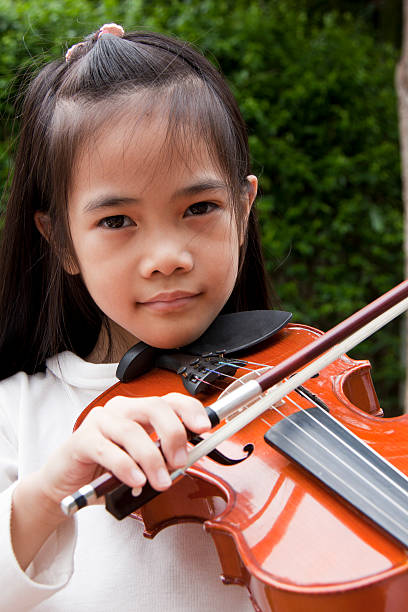 istock little girl playing the violin 513253785