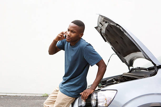 afrikanische mann anrufen auf handy für auto dienst - autopanne stock-fotos und bilder