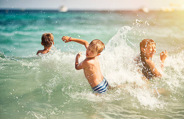 istock Kids having ultimate fun in sea waves 513254320