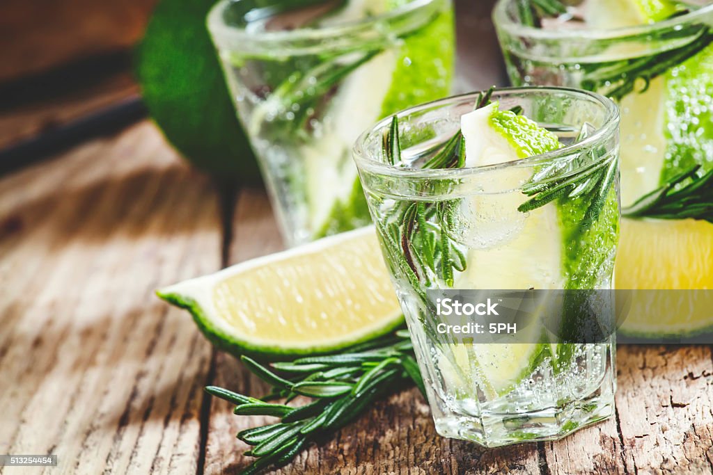 Drink with lime, rosemary, honey and soda Drink with lime, rosemary, honey and soda, pitcher with crushed ice on the old wooden background, selective focus Alcohol - Drink Stock Photo