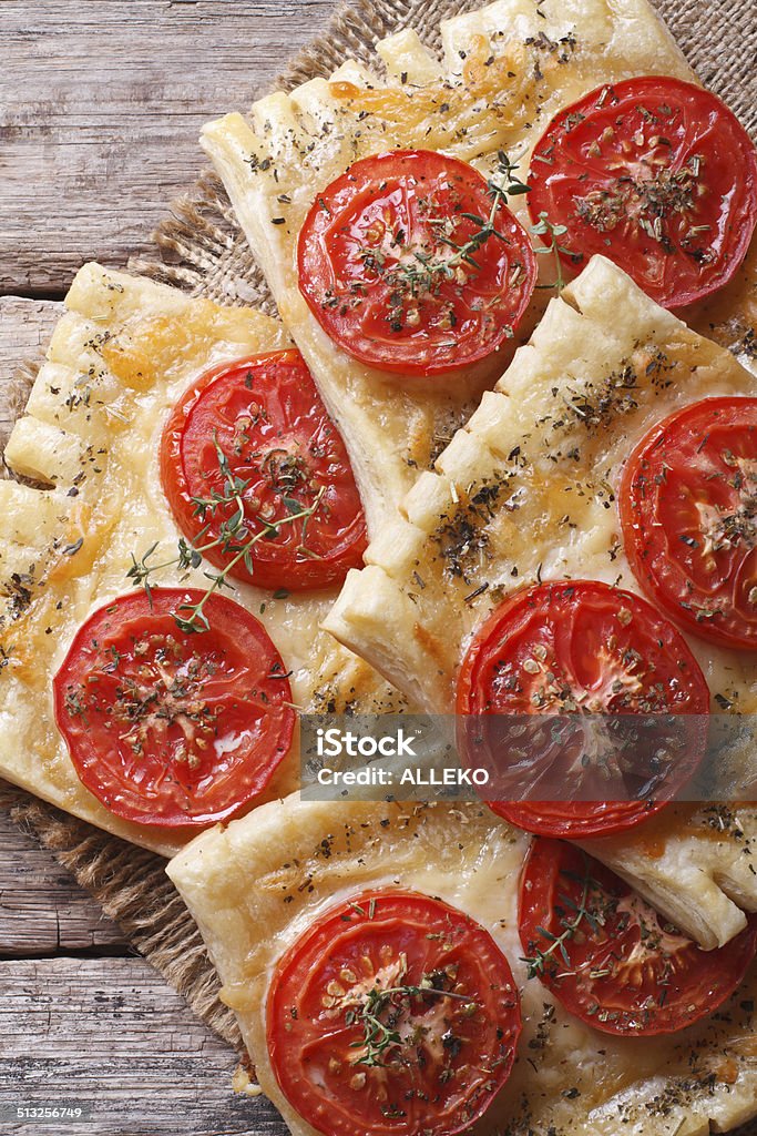 Puff pastry with tomato and cheese vertical. top view Puff pastry with tomato and cheese on the table close-up vertical. top view Above Stock Photo