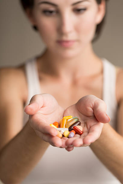 istock Woman holding several pills 513257429