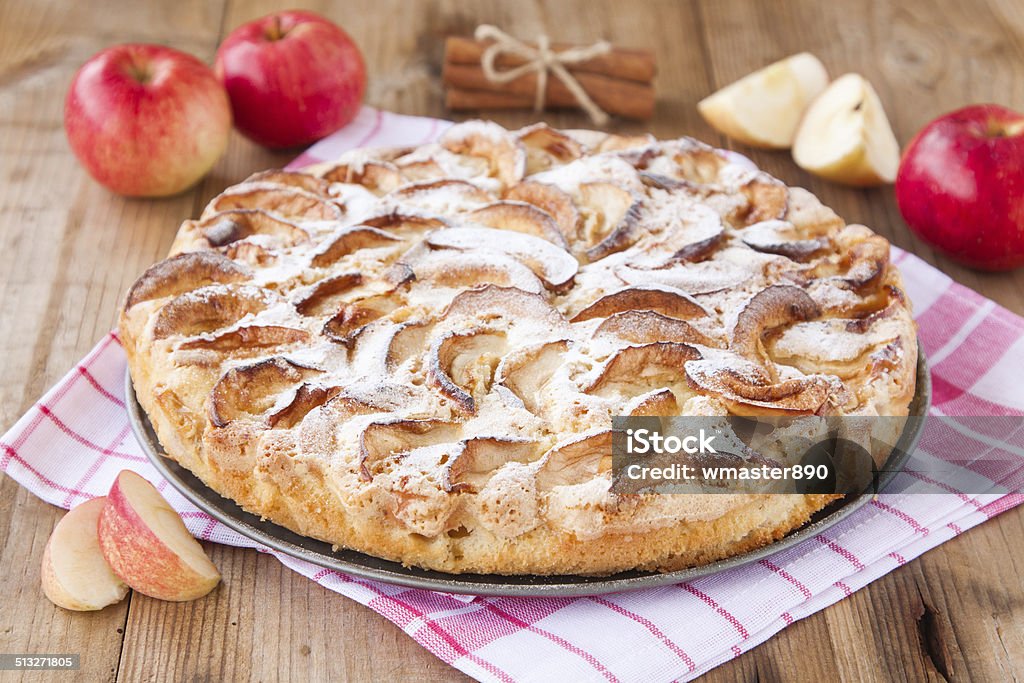 apple pie on a wooden background with cinnamon apple pie on a wooden background with cinnamon and red apples Apple - Fruit Stock Photo