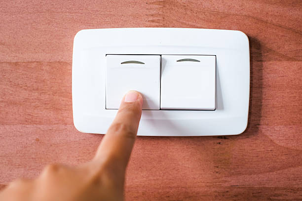 istock Turning off  on wooden wall-mounted light switch - energy saving 513271951