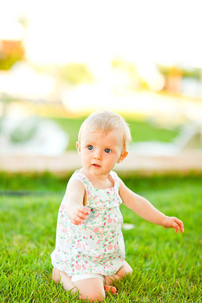 istock interested baby sitting on grass 513274033