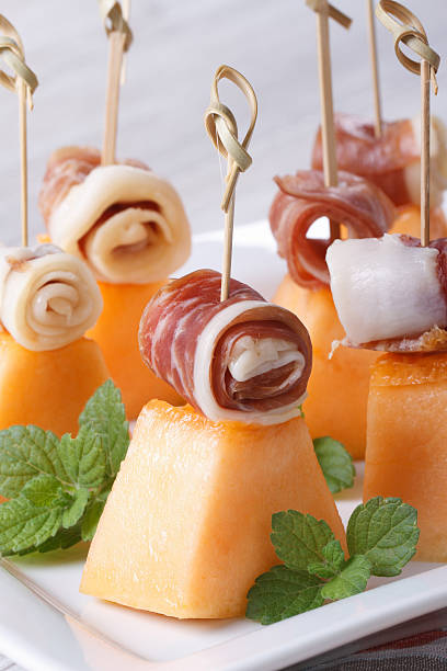 istock Finger food: melon with ham on skewers and mint macro 513274211