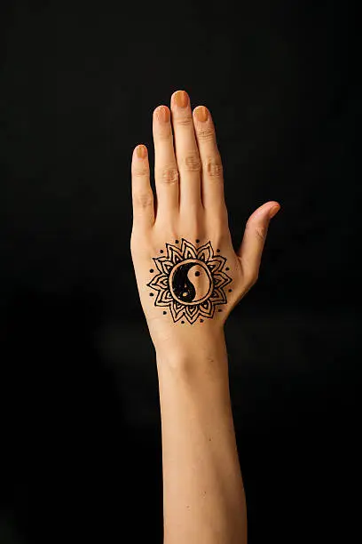 hand with mehendi on black background