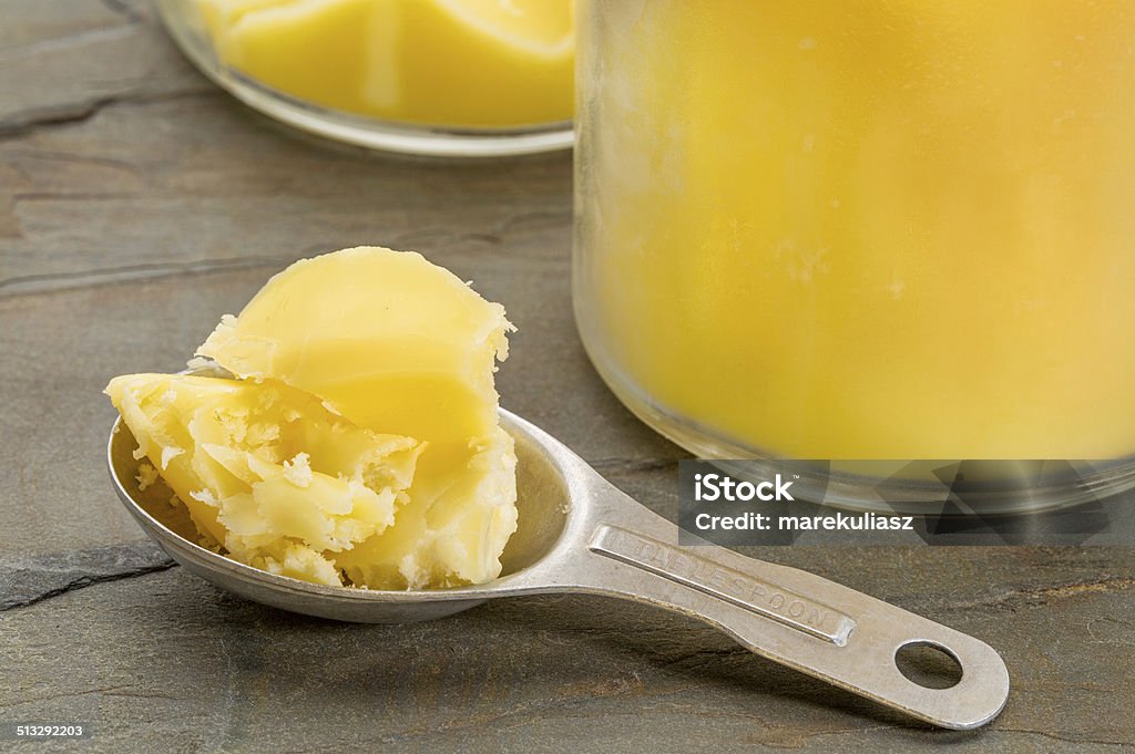 ghee - clarified butter spoon jar sand measuring tablespoon of ghee - clarified butter on grunge wood Butter Stock Photo