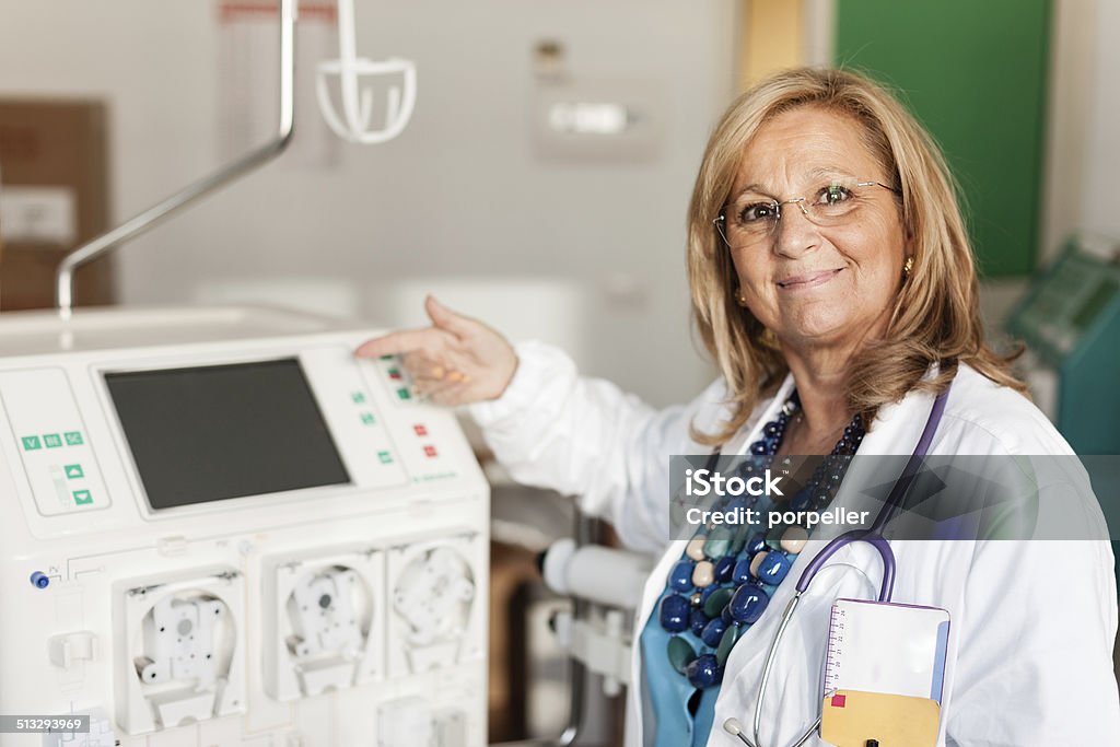 Doctor showing a dialyser a female doctor showing how to use a dialysis machine Dialysis Machine Stock Photo