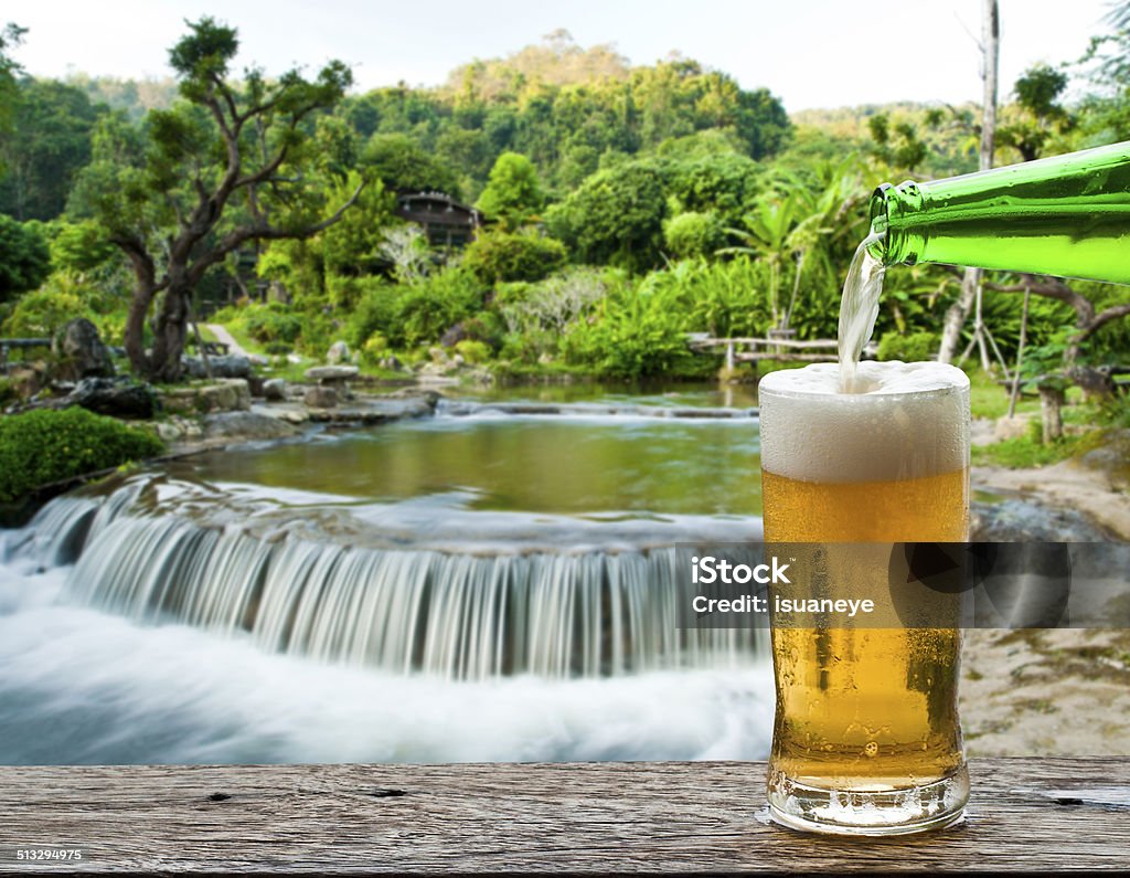 Enjoy beer with waterfall landscape. Alcohol - Drink Stock Photo