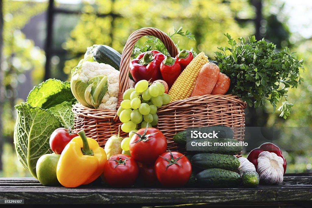 Wicker basket with assorted raw organic vegetables in the garden Wicker basket with assorted raw organic vegetables in the garden. Antioxidant Stock Photo