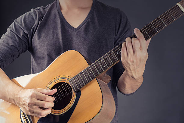 istock Man Playing Acoustic Guitar in Black background 513296086