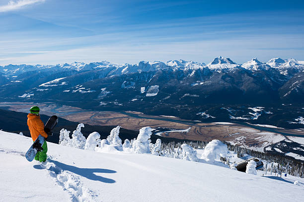 Stunning views at Revelstoke Mountain Resort Snowboarder enjoying stunning views at Revelstoke Mountain Resort revelstoke stock pictures, royalty-free photos & images
