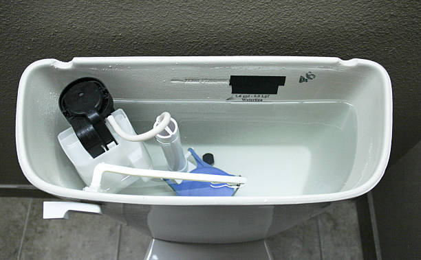 Internal Plumbing of a Modern Toilet Internal plumbing of the inside of a tank of a modern toilet flushing valve public restroom toilet stock pictures, royalty-free photos & images