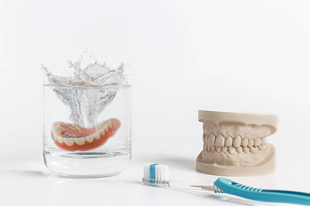istock Denture hygiene concept with glass and toothbrush 513298248
