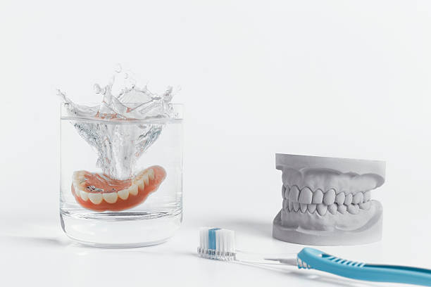 istock Denture hygiene concept with glass and toothbrush 513298278