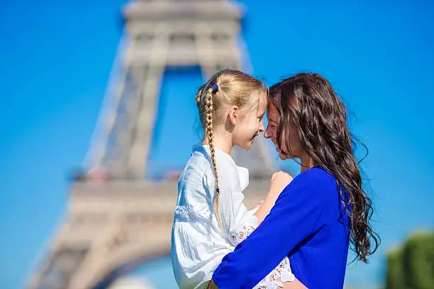 Photo of Adorable girl and happy mother in Paris background Eiffel Tower