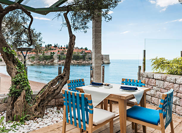 Tables at seaside restaurant Tables at seaside restaurant with beautiful view on the island Saint Stephen in Montenegro budva stock pictures, royalty-free photos & images