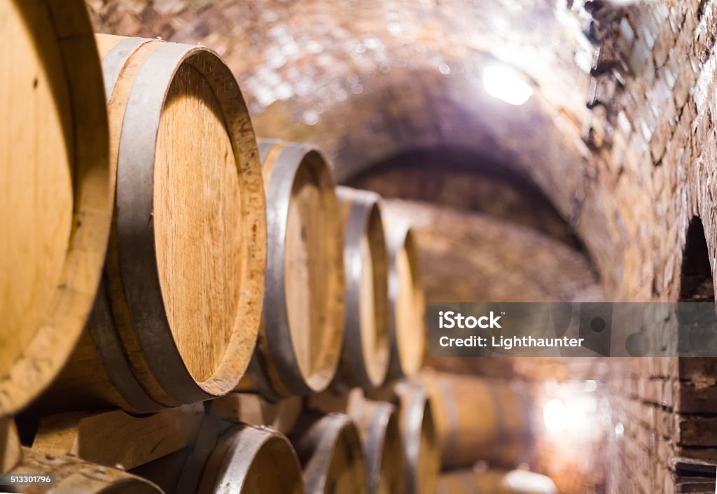 Wine cellar Oak barrels containing wine stacked up in cellar. Backgrounds Stock Photo