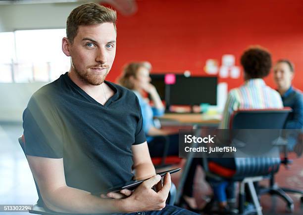 Confident Male Designer Working On A Digital Tablet In Red Stock Photo - Download Image Now