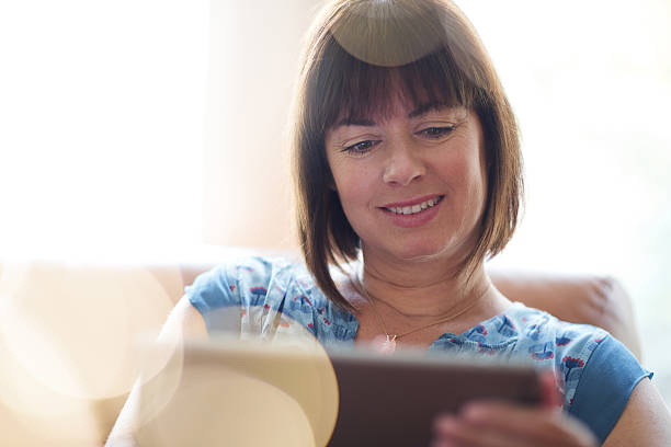 istock Mature woman browsing the internet on a digital tablet 513302490