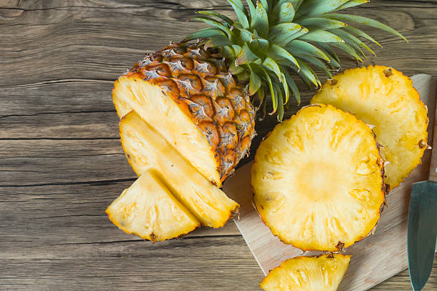 istock pineapple on the wood texture background 513302624