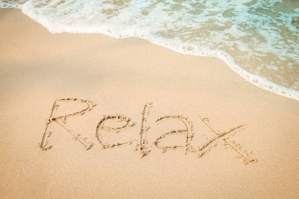 istock Relax message hand writing on the sand beach 513305144