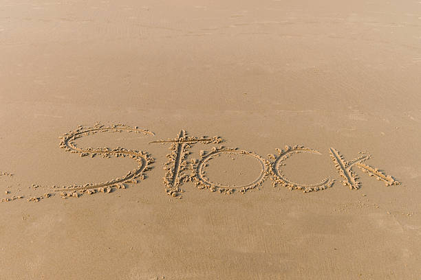 istock Word stock writing in sand, on sunset beach 513305692