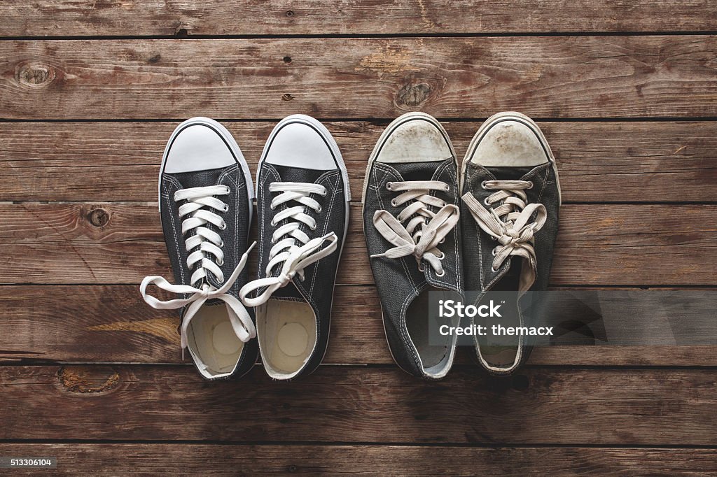 New and old sneakers on wooden background New and old sneakers on wooden background. Shoe Stock Photo