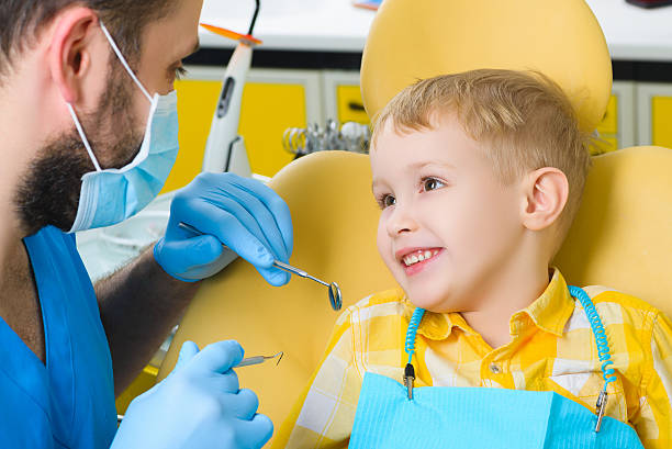 Close up of boy having his teeth examined by a stock photo